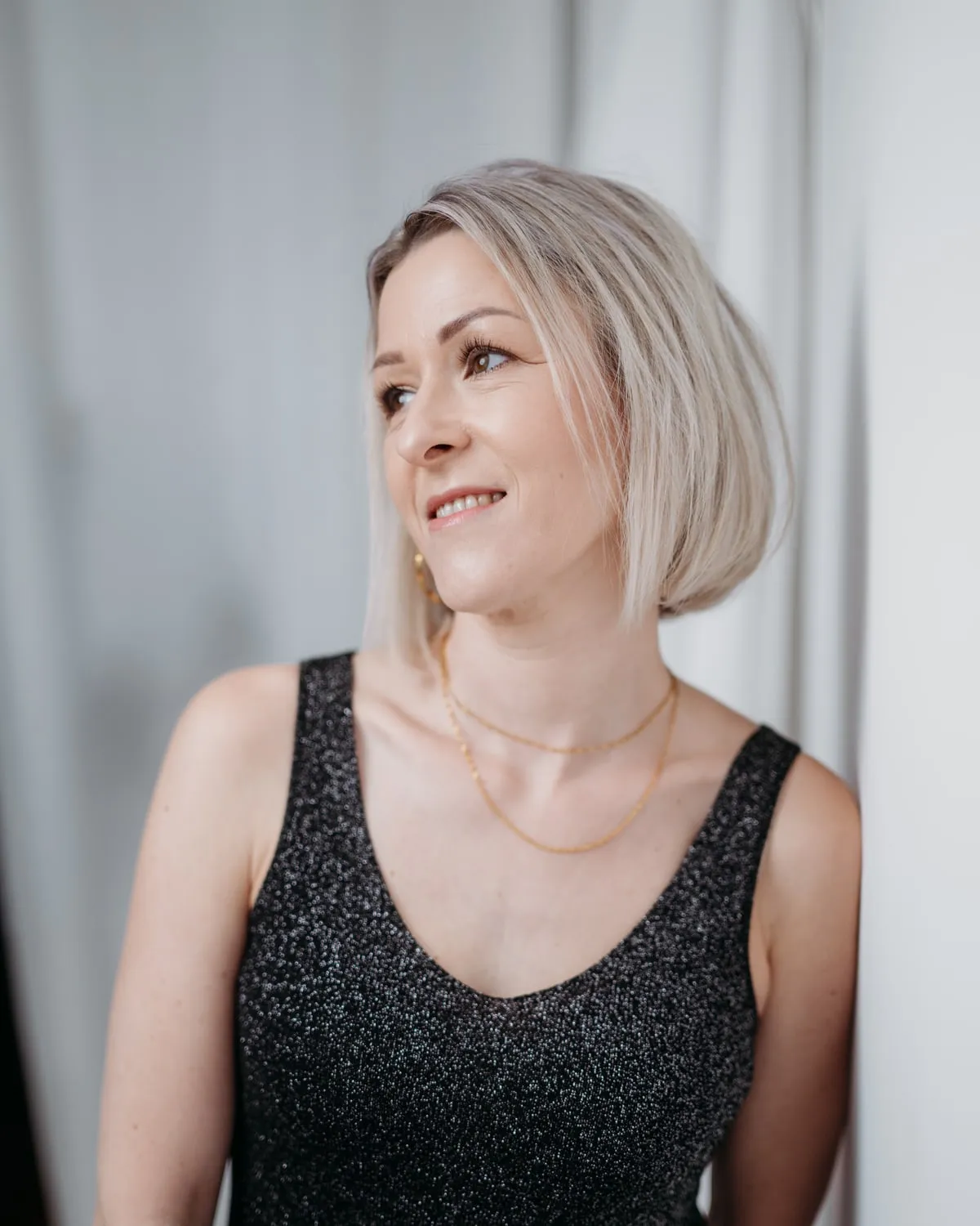 Christina Hohensinn steht am Fenster ihres Studios und lächelt zur Seite