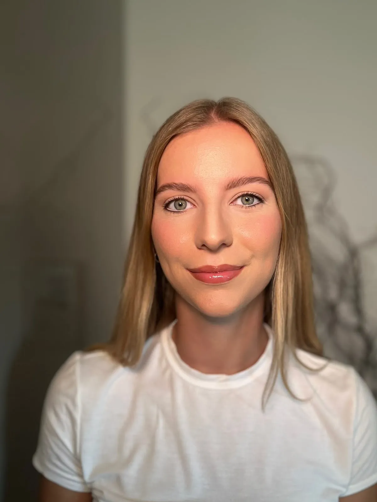 Dieselbe blonde Frau mit natürlichem Tages-Make-up und offenen glatten Haaren